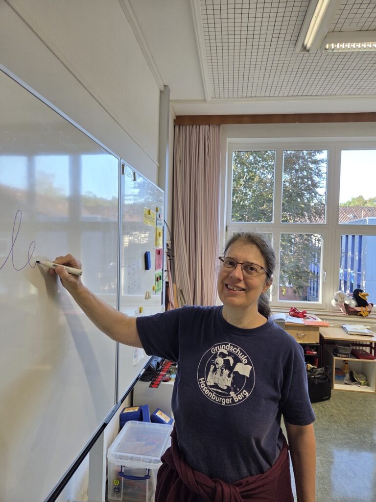 Lehrerin der Grundschule Hasenburger Berg, Frau Bankewitz, im Klassenraum mit Kreide an der Tafel