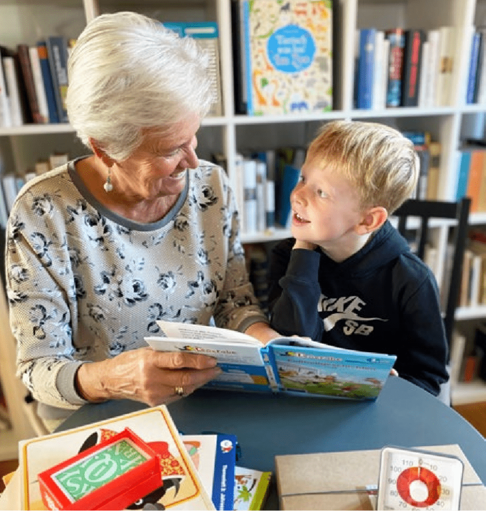 Lesementorin liest mit einem Grundschulkind